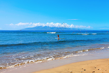 热带海滩有蓝水和冲浪者图片