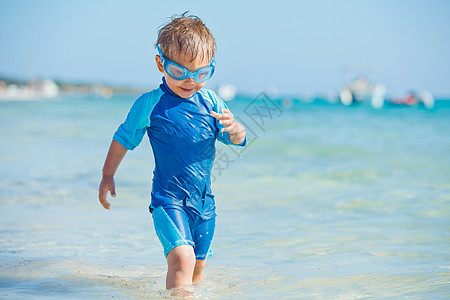 海滩上一个可爱的男孩运动海洋护目镜游泳者童年闲暇浮潜假期蓝色微笑图片