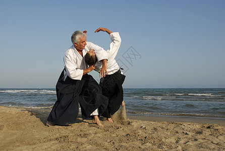 在海滩上训练合木道操作成人运动格斗武士说明瞳孔男人专注海洋图片