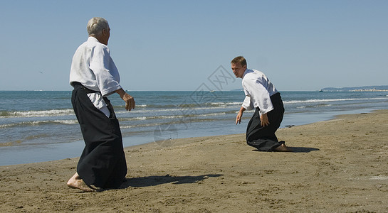在海滩上训练合木道成人说明瞳孔男人海洋运动操作专注格斗武士图片