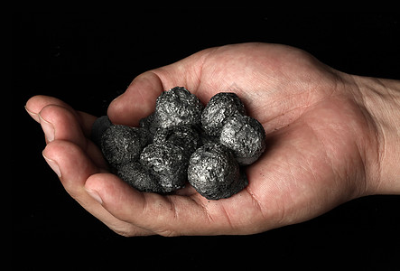 手握着一堆煤炭图片