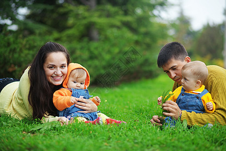 双胞胎父母快乐父亲青年女士家庭公园喜悦育儿母亲男性月份图片