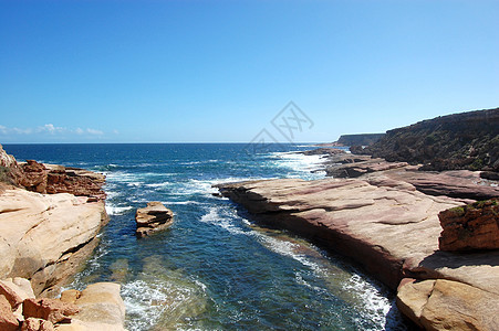 海岸的岩石波浪石头海浪支撑红色悬崖海洋蓝色蓝天图片