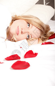 与玫瑰桃子睡在床上的妇女图片