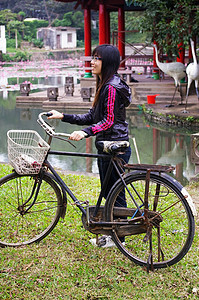 带着微笑骑自行车的亚洲妇女图片