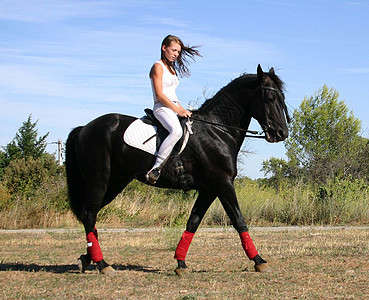 年轻妇女和马天空白色马术场地黑色运动青少年宠物蓝色骑马图片