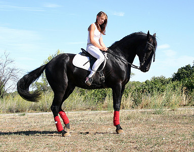 年轻妇女和马男性青少年动物骑马头盔宠物女孩场地天空白色图片