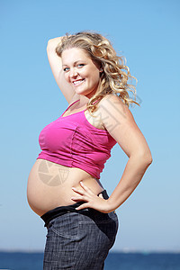 怀孕肚子成人蓝色分娩女士海滩闲暇父母女孩母性图片
