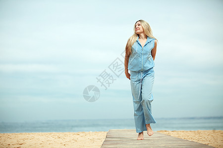 女人睡在沙滩上女士快乐假期蓝色旅行喜悦金发女性头发闲暇图片