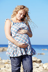 怀孕海滩母亲天空冒充微笑蓝色女性成人闲暇女士图片