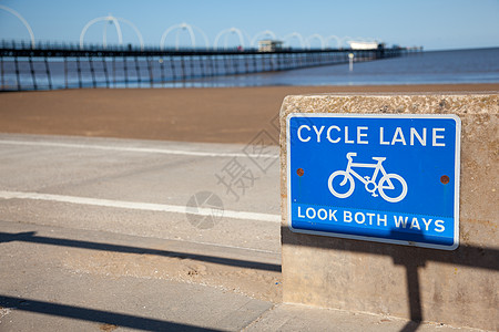 蓝色自行车道路在海滩前的车道标志指示牌路标白线危险阴影小路长廊图片