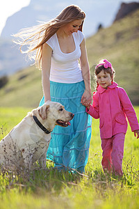 与狗一起走的幸福家庭宠物乐趣动物女孩孩子女士父母自由假期团体图片