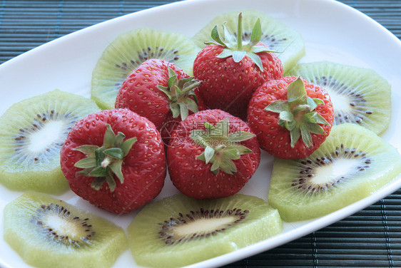 Kiwi和草莓在白盘上宏观茶点红色热带白色水果奇异果盘子食物绿色图片