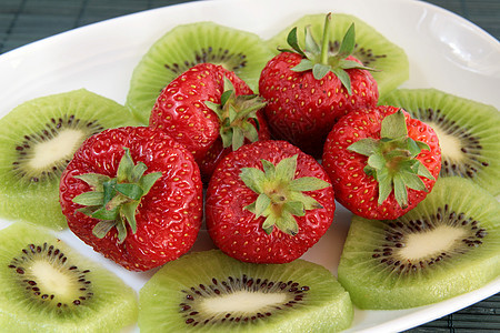 Kiwi和草莓在白盘上红色宏观水果绿色茶点食物种子甜点盘子奇异果图片