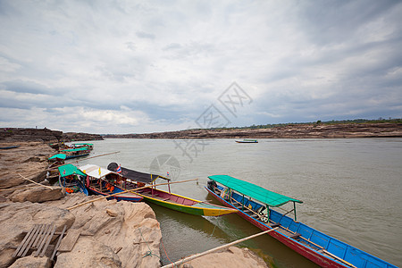 湄公河中的渔船木头洞穴石头岩石码头鸿沟反射沟壑钓鱼天空图片