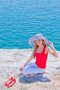 女孩在岩石上海对岸地平线海滩天空青年边缘河岸海岸线场景女性沉思图片