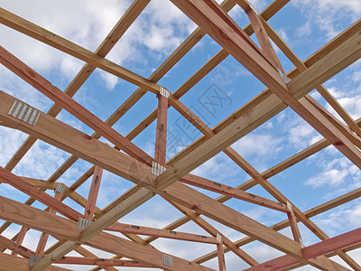 在云彩蓝天下建造屋顶板架建筑桁架沥青工作屋顶木工财产木板房地产木材图片