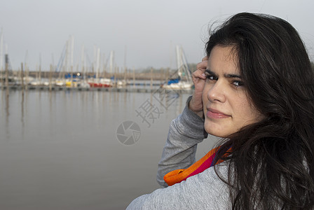 年轻妇女的肖像长发帆船围巾海岸黑发港口女孩图片