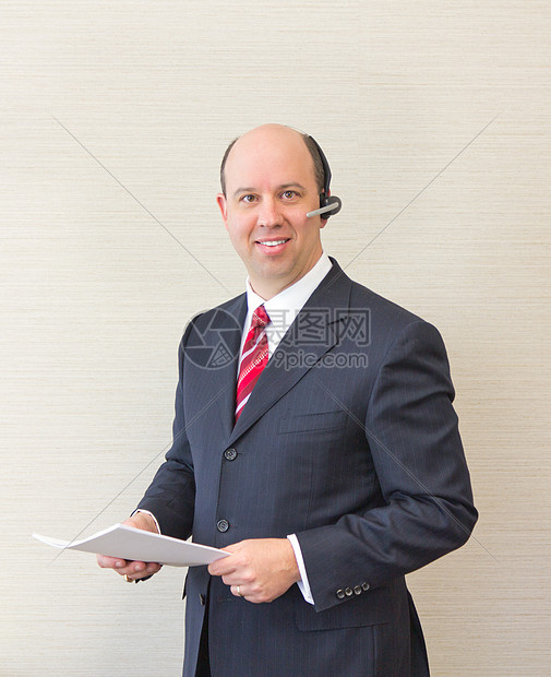 戴耳头和文件的商务人士文档管理人员电话正装首席耳机企业家套装老板男性图片