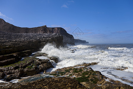 海岸悬崖岩石侵蚀戏剧性白色海洋巨石太阳海藻海滩图片