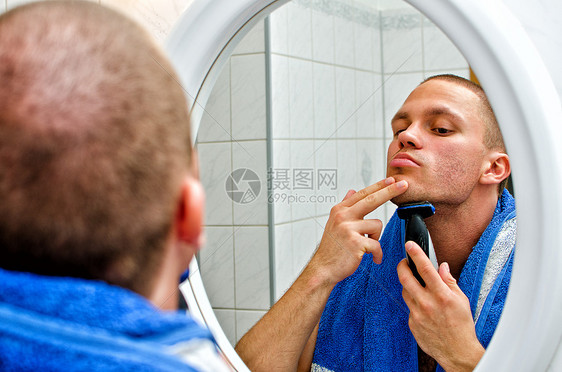 男人在镜子前的浴室里刮毛巾专注胡须护理卫生剃刀剃须反射皮肤剃须刀修饰图片