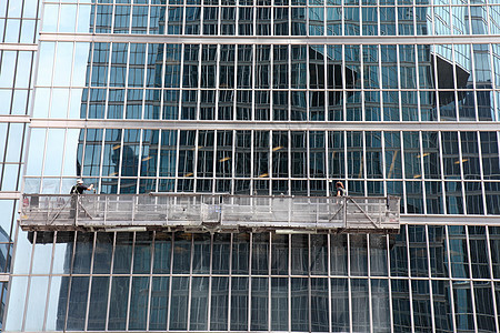 现代高楼办公室的窗户擦洗窗头窗格刮板天空工作绳索高度男性玻璃职业反射图片