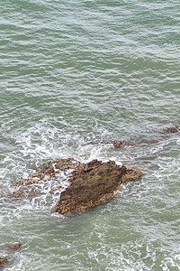 热带海滩上的石头天空冲浪海景阳光海岸太阳蓝色地平线岩石海洋图片
