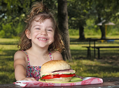 快乐的小女孩在公园野餐图片