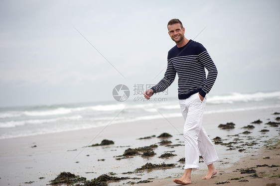 年轻人在海滩上散步蓝色海岸海洋自由海浪健康海藻男人太阳享受图片