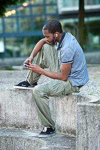 黑人青年男性 在外边听耳语音乐节目图片