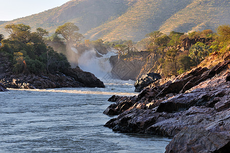 Epupa瀑布日出 纳米比亚峡谷巨石急流岩石悬崖太阳戏剧性日落洪水阴影图片