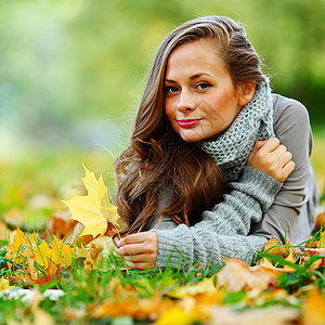 秋叶中的妇女脚尖叶子季节女士微笑幸福眼睛乐趣团体女孩毛衣图片