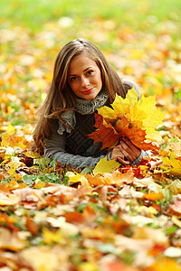 秋叶中的妇女脚尖眼睛金发女郎毛衣感恩幸福女孩女士头发乐趣公园图片