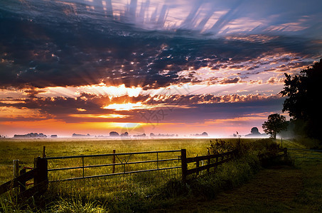 农村格罗宁根的彩色日出绿色阳光场地村庄风景牧场草地天空栅栏戏剧性图片