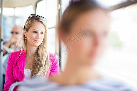 坐在街车火车道上的漂亮年轻女子女孩市中心邮票乘客旅行交通公共汽车控制器女性有轨电车图片
