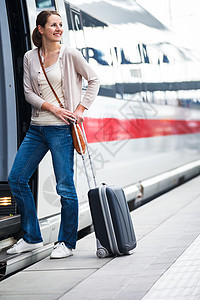 美丽的年轻女子登上火车运输城市女性游客大厅城际行李车辆车皮女孩图片