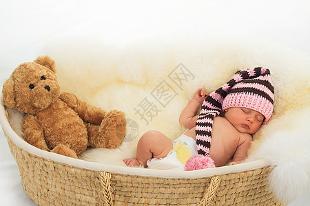 婴儿睡在一只白羊皮上 躺在篮子里快乐男性说谎女孩母亲乐趣工作室生活女儿喜悦图片