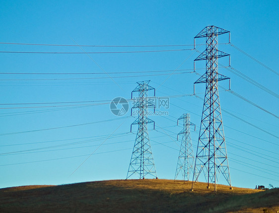 蓝天前的山丘上的电线供电网格公用事业导体天空电路爬坡桅杆环境网络图片