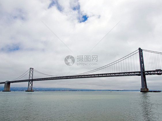 旧金山湾大桥在云天旅行地标天空历史性工程电缆交通天际汽车旅游图片