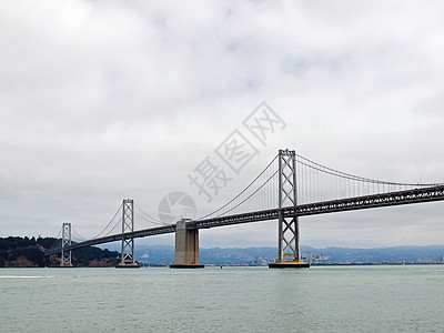 旧金山湾大桥在云天工程交通历史性金属海岸跨度市中心建筑天际汽车图片