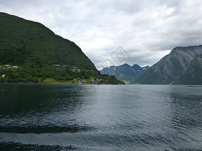 浮游和山峰房屋多云山脉山腰海岸悬崖绿色波浪峡湾船屋图片