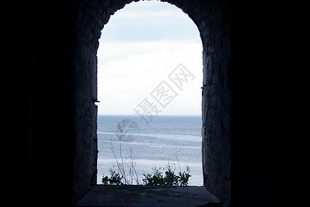 透过古老石碑堡垒的窗户看海图片