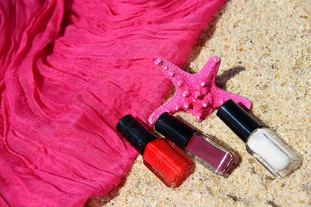 沙滩和粉色围巾上的指甲油瓶图片