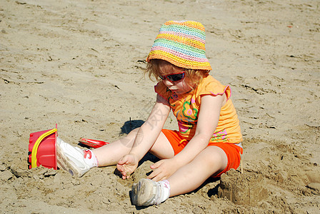 美丽的小女孩在沙沙中玩耍图片