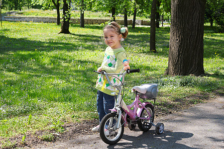 带着自行车在公园里摆着的小女孩图片
