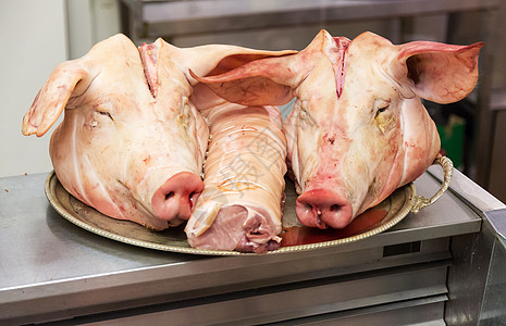 两个猪头在屠夫店的盘子上图片