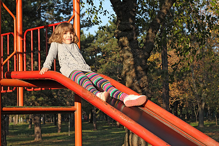在游乐场的小女孩童年快乐女性白色冒充乐趣公园闲暇孩子操场图片