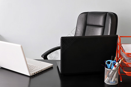 配有两台膝上型电脑的服务台黑色办公室扶手椅笔记本灰色皮革桌子椅子白色工作背景图片