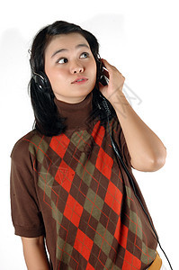 年轻女子用耳机监听音乐女孩成人女士微笑享受女性青年文化幸福手机图片