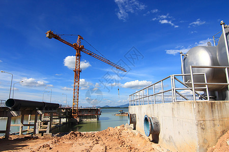 背景有起重的建筑工地燃料起重机天空管道生长管子高楼气体工程工作图片